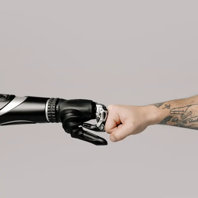 A robotic hand and a human hand fist-bumping, representing technology and people working together